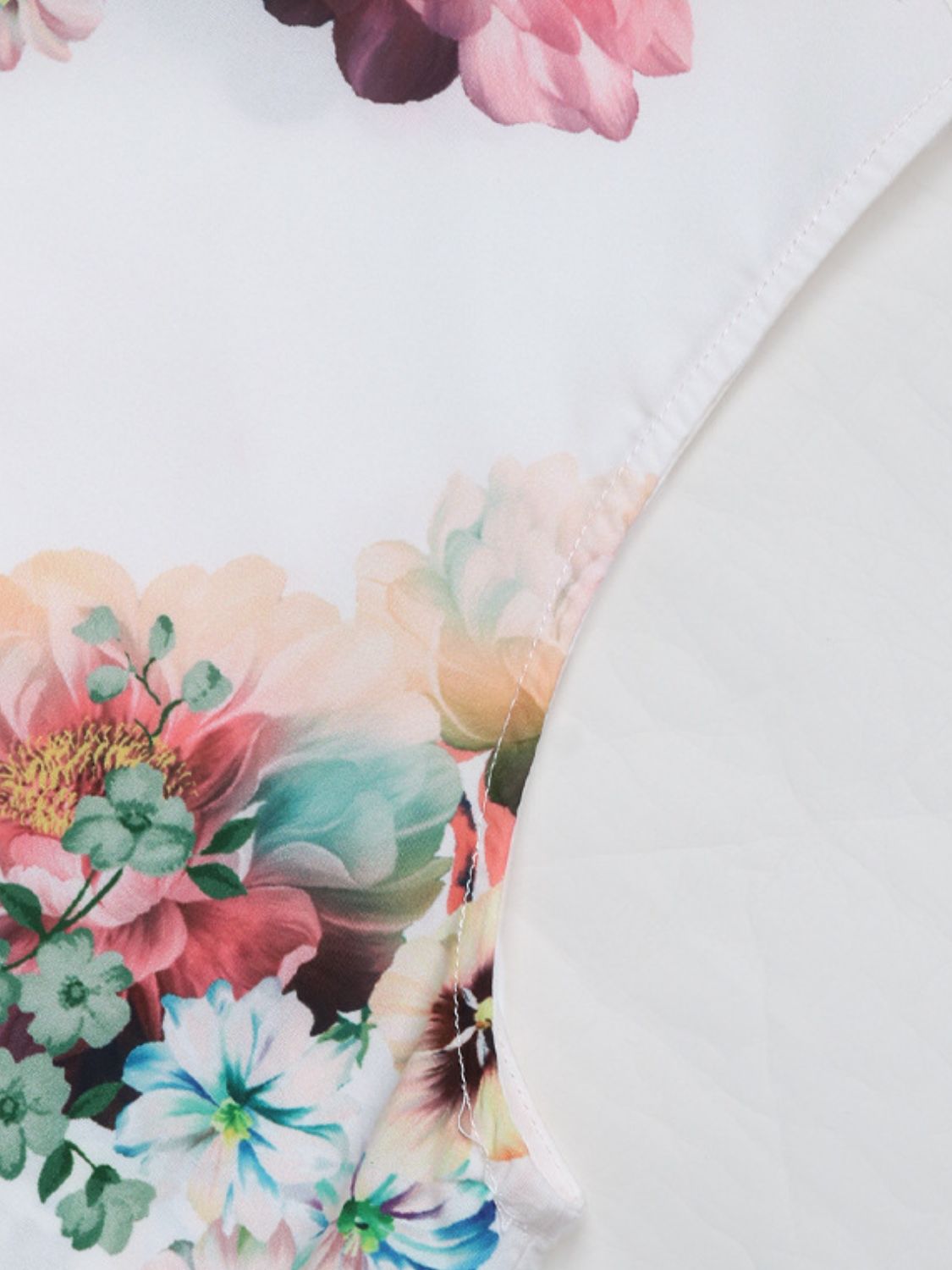 Painterly floral sleeveless blouse in Gum Leaf with a bow-neck detail.