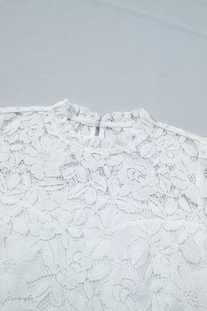White lace blouse with ruffled mock neckline and floral pattern.
