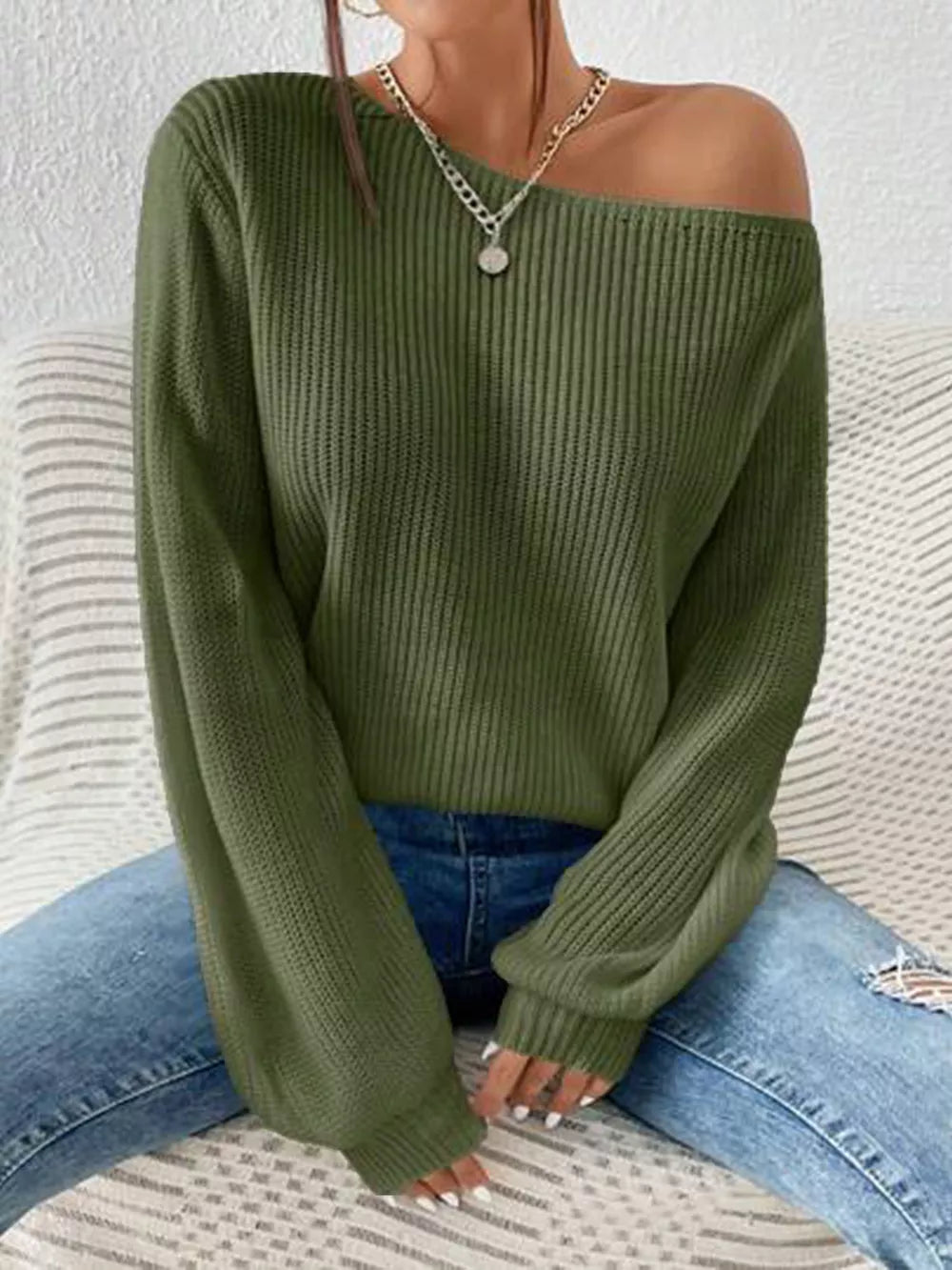 Dark green asymmetrical knit sweater with off-shoulder neckline and ribbed texture.