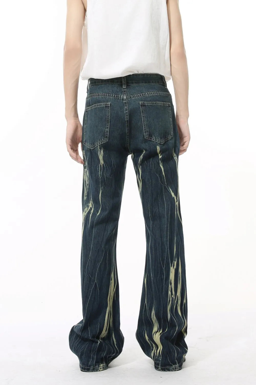 Faded flare denim jeans in dark wash with abstract light yellow distressed pattern.
