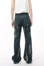 Faded flare denim jeans in dark wash with abstract light yellow distressed pattern.
