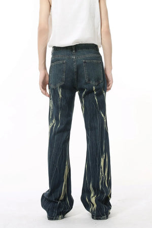 Faded flare denim jeans in dark wash with abstract light yellow distressed pattern.