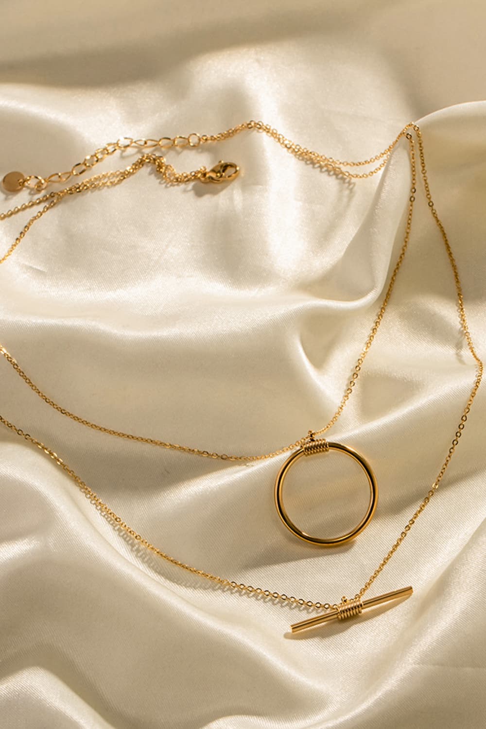 Gold double-layered necklace with geometric circle and bar pendants