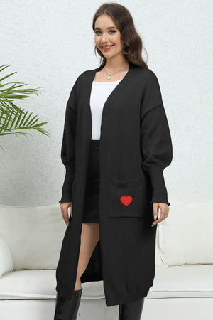 Black long cardigan with balloon sleeves and a red heart pocket detail.