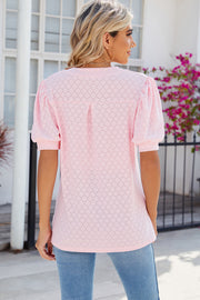 Blush pink eyelet V-neck blouse with puff sleeves and a diamond pattern.