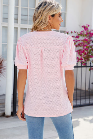 Blush pink eyelet V-neck blouse with puff sleeves and a diamond pattern.