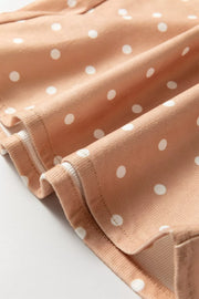 Peach polka dot maternity trousers with wide legs and drawstring detail.