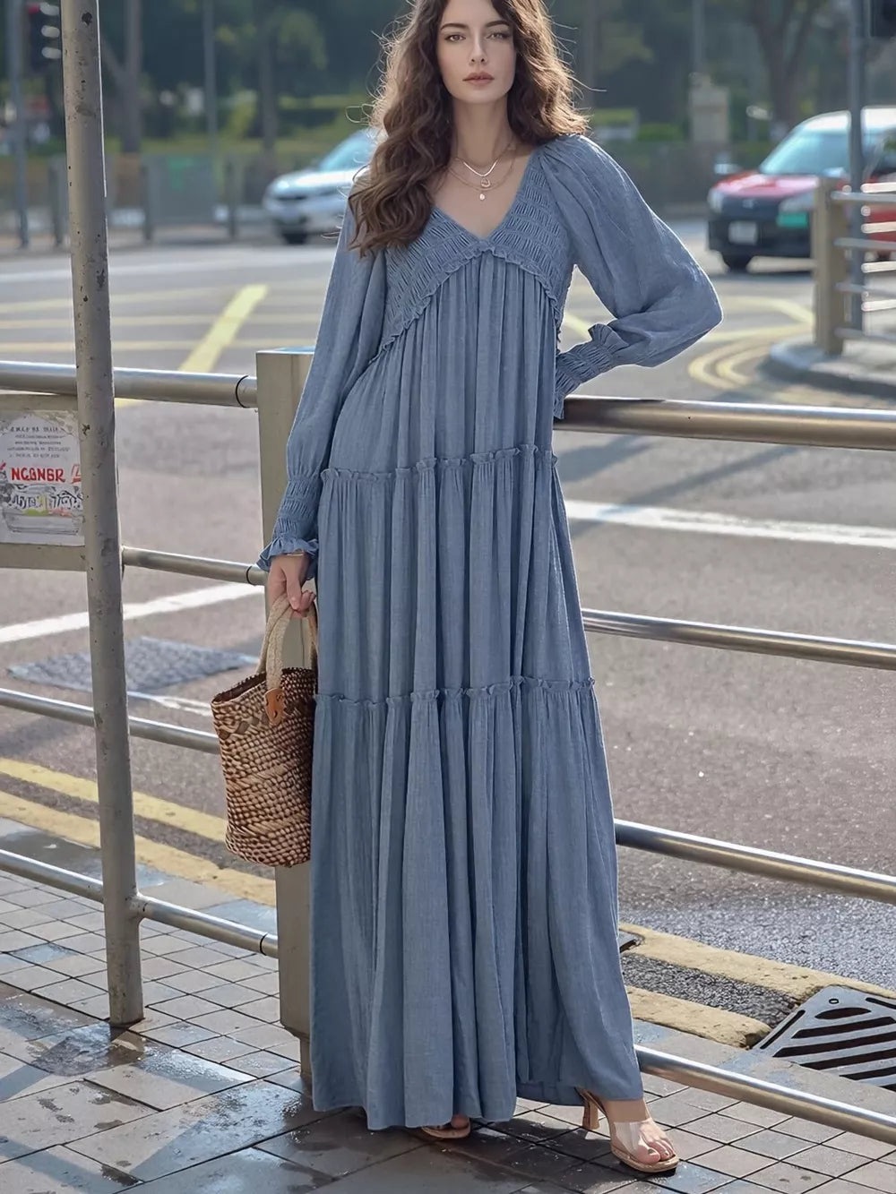 Blue smocked V-neck tiered maxi dress with long sleeves and a basket bag.