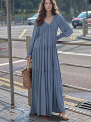 Blue smocked V-neck tiered maxi dress with long sleeves and a basket bag.