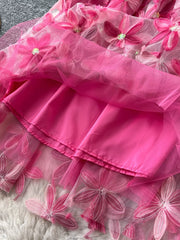 Pink layered skirt with embroidered floral details and a satin lining.