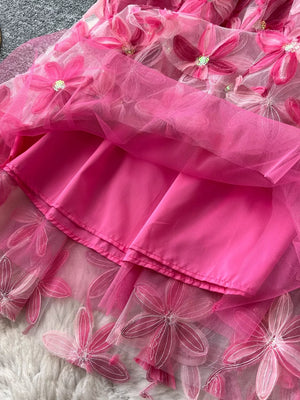 Pink layered skirt with embroidered floral details and a satin lining.