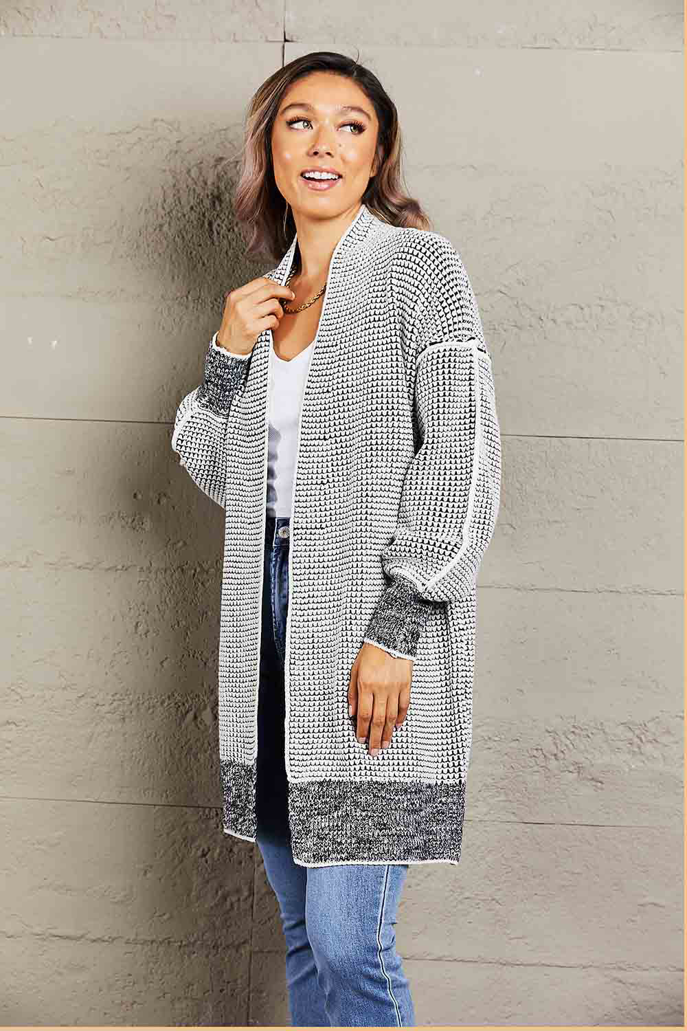 Textured puff sleeve open cardigan in black with a waffle knit pattern and contrast cuffs and hem.