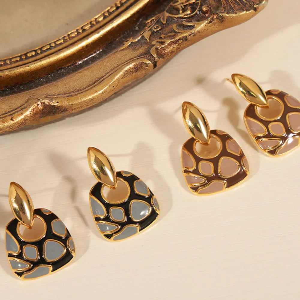 Geometric enamel drop earrings in black and brown with gold accents.