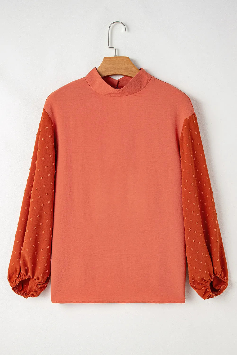 Orange blouson top with mock neck and textured Swiss dot puff sleeves