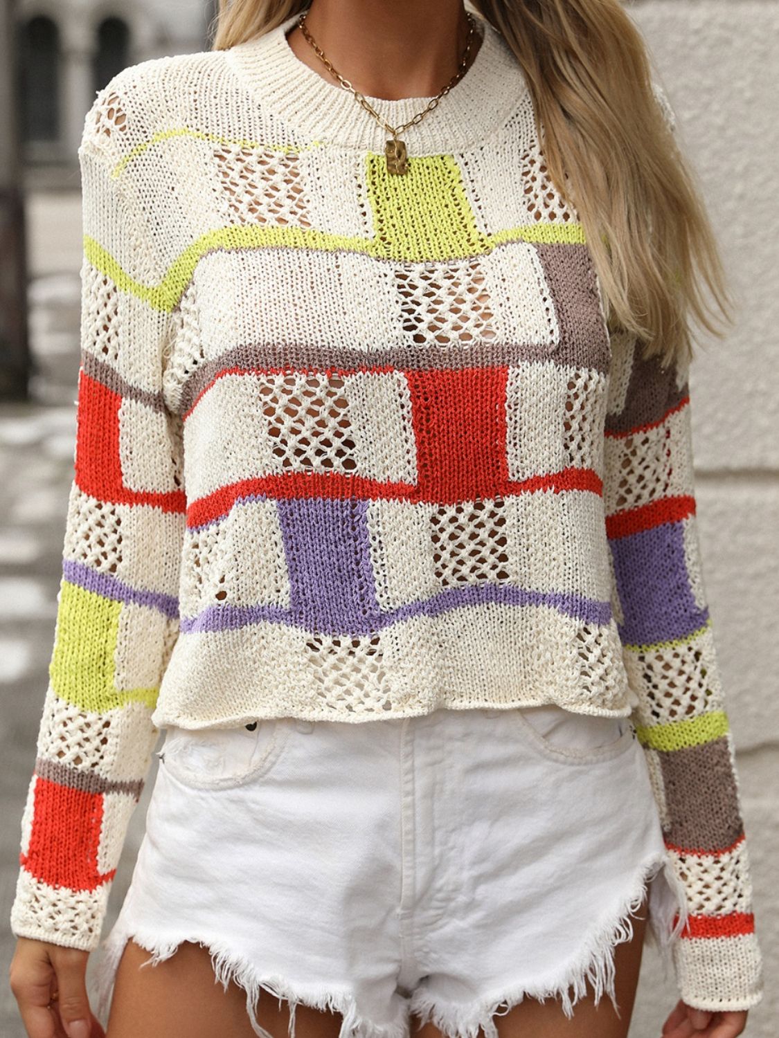 Patchwork openwork knit sweater with colorful blocks and open knit details.