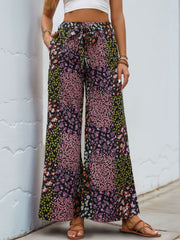 Black floral panel palazzo trousers with a tie waist and wide legs.