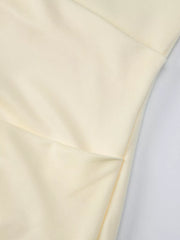 Yellow ruched maxi dress detail showing fabric texture and seam.