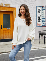 White acrylic crewneck sweater with balloon sleeves and ribbed cuffs, styled with jeans.