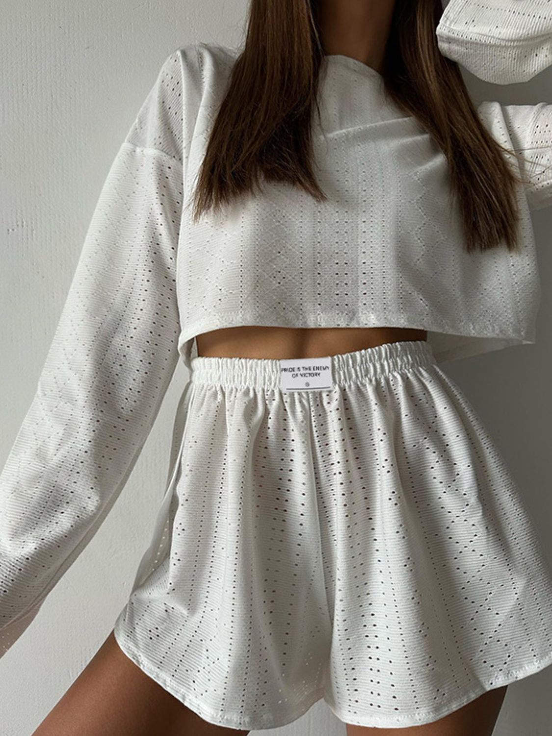 White perforated crop top and shorts set with elastic waistband and crew neck.