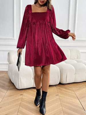 Chic velvet mini dress with square neckline and long sleeves in a rich red hue.