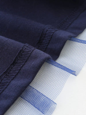 Dark navy baby dress detail showing layered tulle trim and stitched seams.