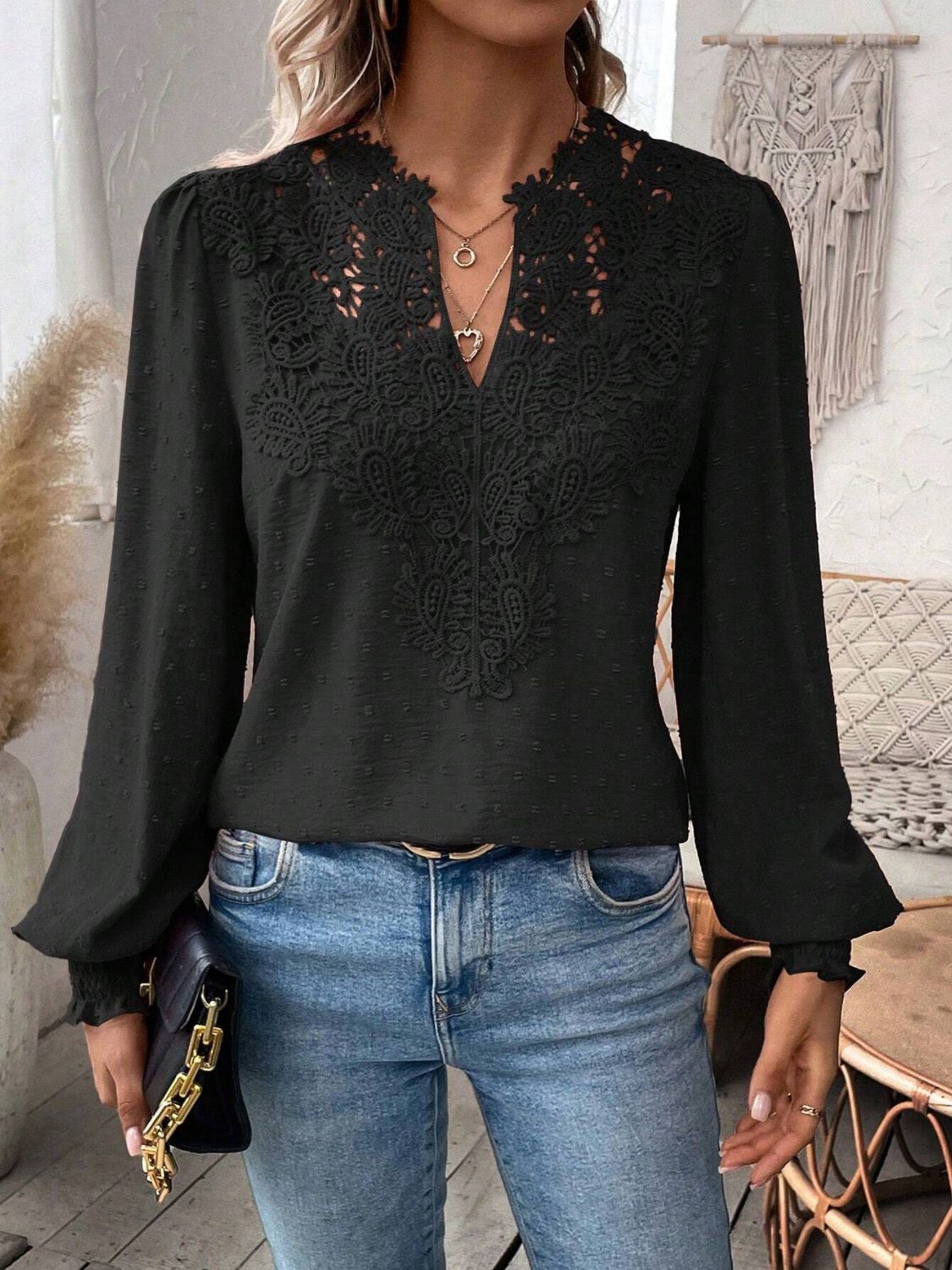 Black embroidered yoke blouse with puff sleeves and textured fabric.