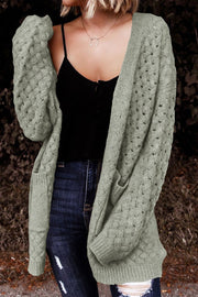 Sage open-knit pocket cardigan with textured sleeves and a relaxed fit.