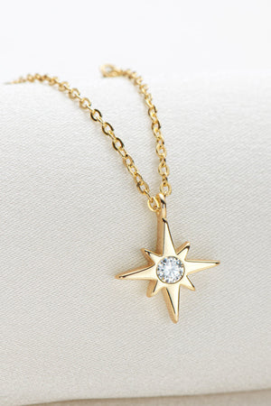 Gold celestial compass pendant necklace with moissanite on a delicate chain.