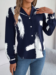 Dark blue collared blouse with white brushstroke print, button front, and long sleeves.
