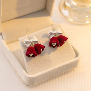 Velvet bell earrings in deep red with white bows and pearl accents.