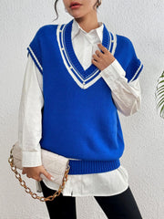 Blue acrylic knit vest with varsity stripes and pearl trim, V-neck, sleeveless, layered over a white shirt.