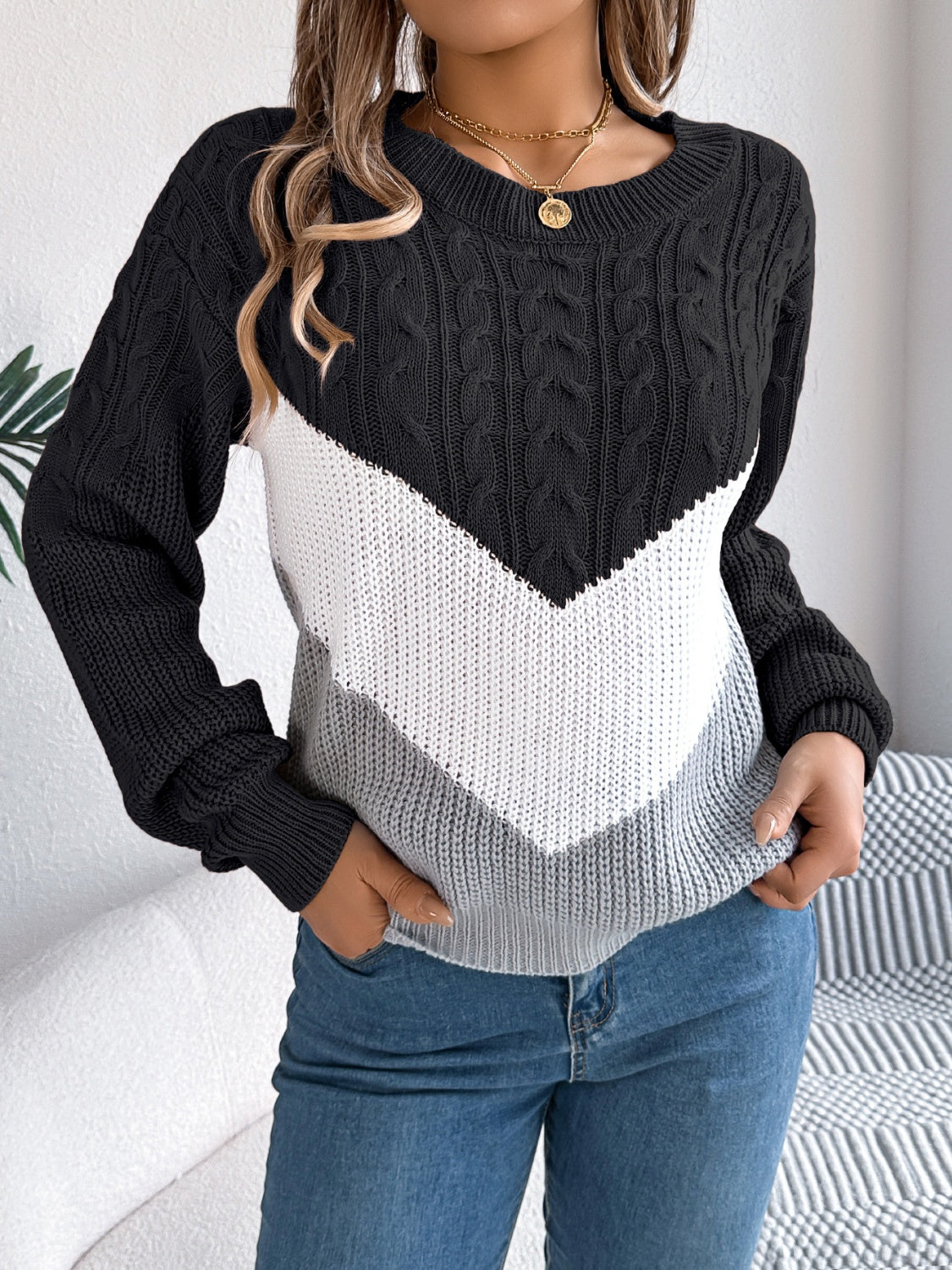Black chevron cable knit sweater with white and grey colorblock detail.