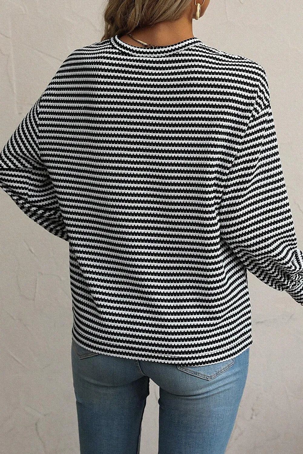 Black and white striped long sleeve tee with a crew neck, casual fit.