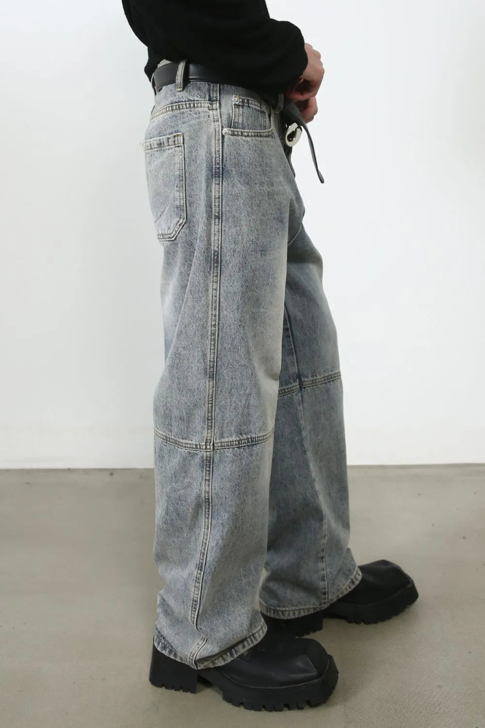 Baggy distressed medium wash cargo jeans with paneling detail.