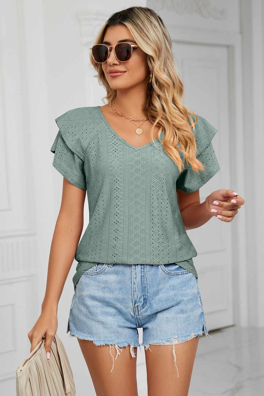 Teal eyelet knit v-neck blouse with flutter sleeves and diamond pattern detail.