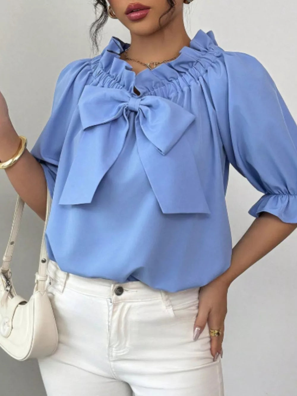 Sky blue ruffled bow sleeve blouse with cinched neckline and ruffled cuffs.