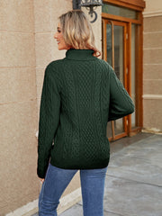 Green cable knit turtleneck sweater with detailed cable patterns.