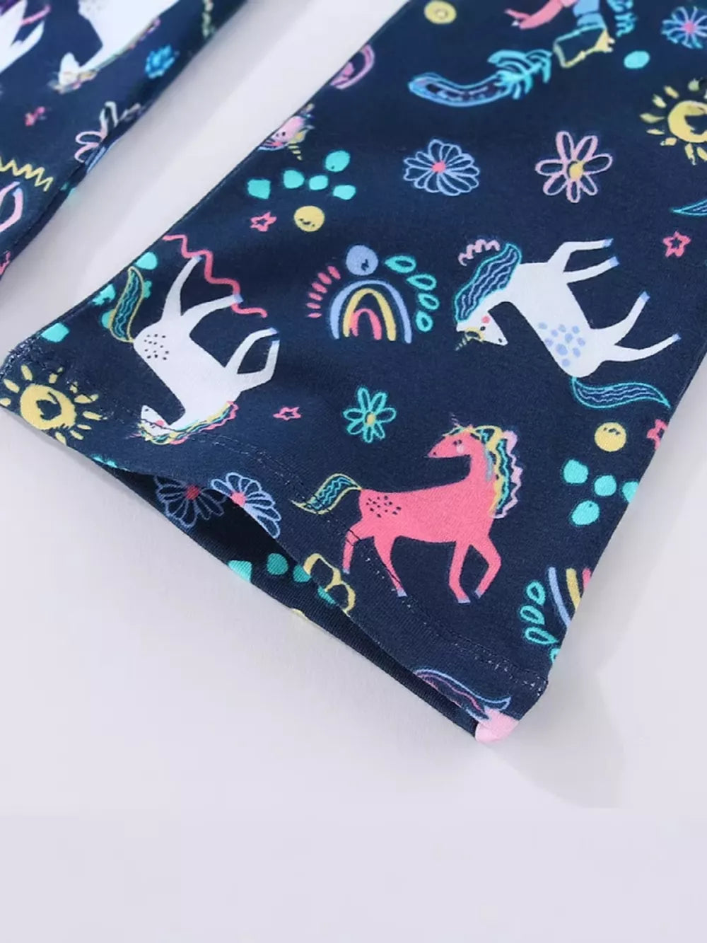 Toddler leggings with a navy blue background and a colorful unicorn and rainbow print.