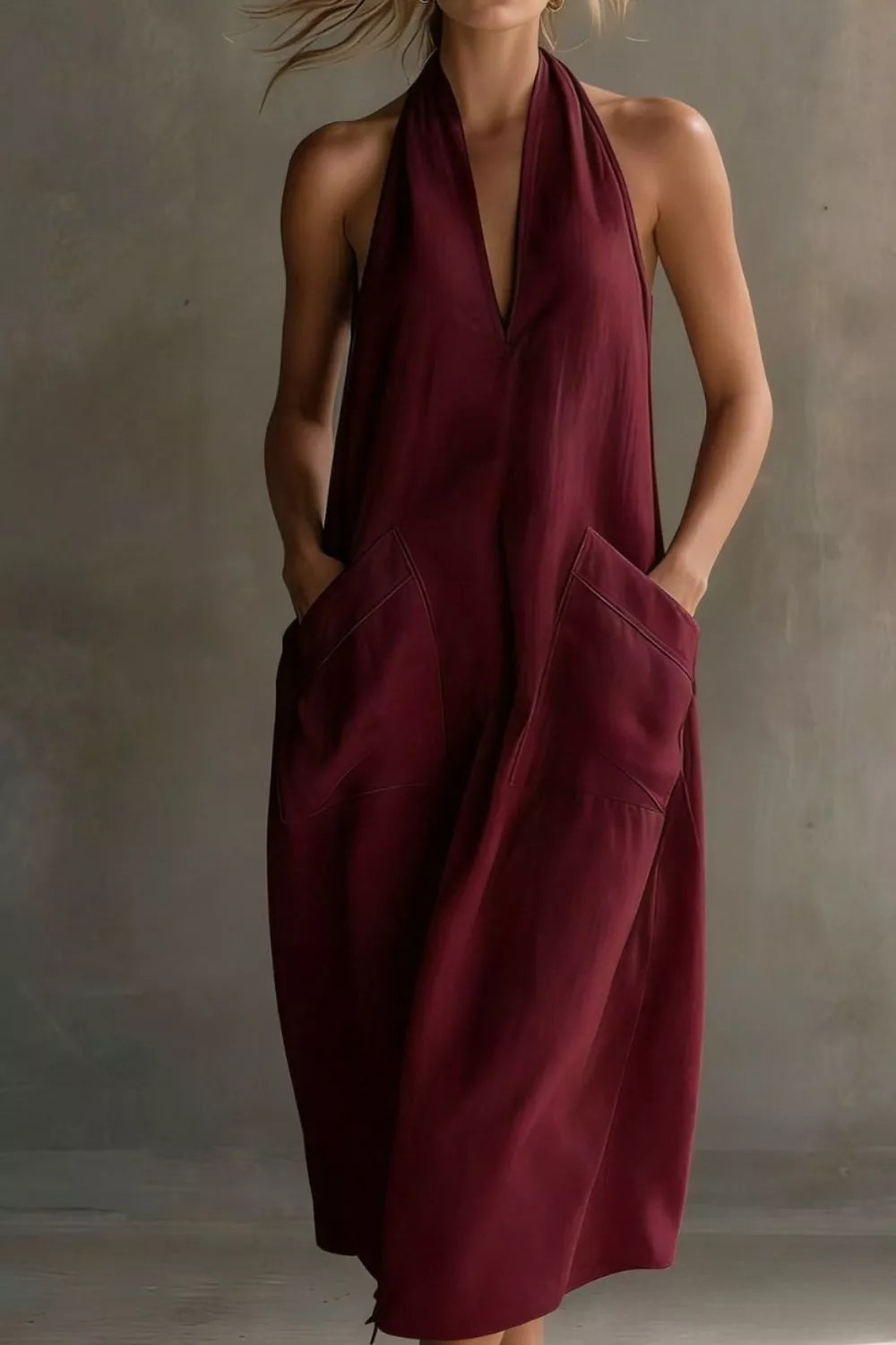 Burgundy halter midi dress with deep V-neck and large front pockets.