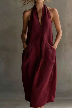 Burgundy halter midi dress with deep V-neck and large front pockets.