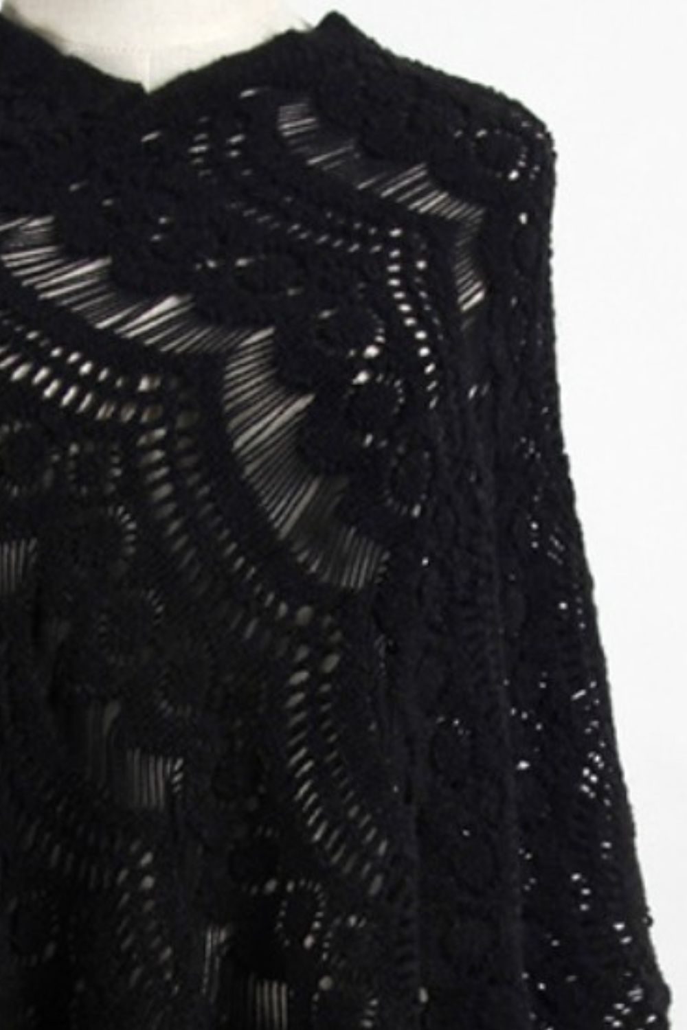 Black crochet poncho with open knit pattern and fringe detail