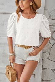 White textured puff-sleeve blouse with pom-pom details and a round neckline.