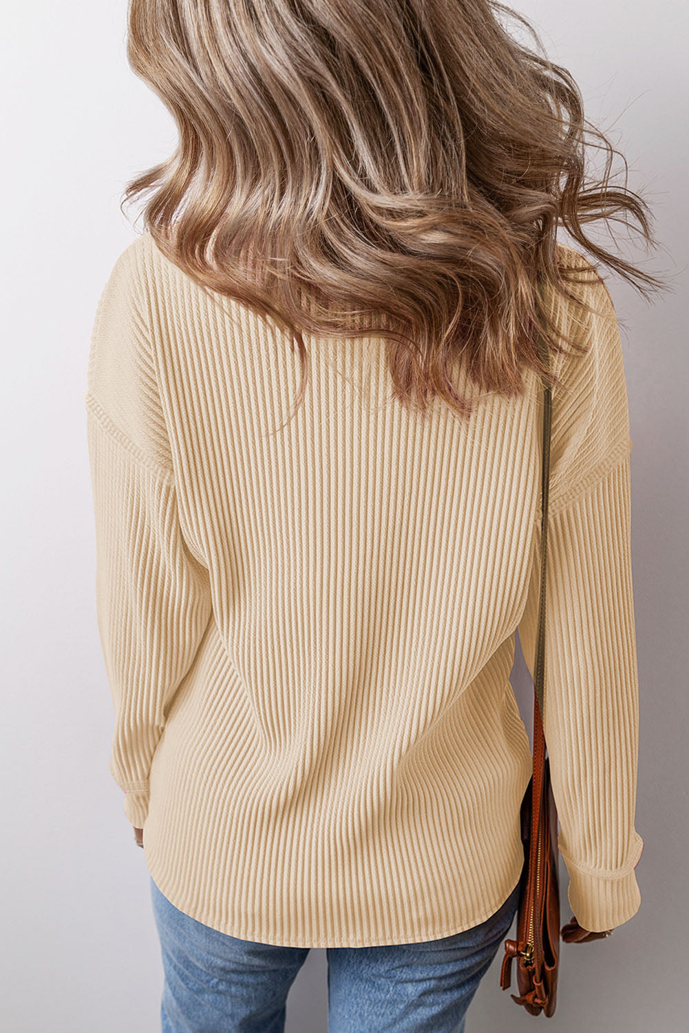 Tan ribbed knit long sleeve top with a relaxed fit and curved hem.