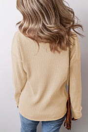 Tan ribbed knit long sleeve top with a relaxed fit and curved hem.