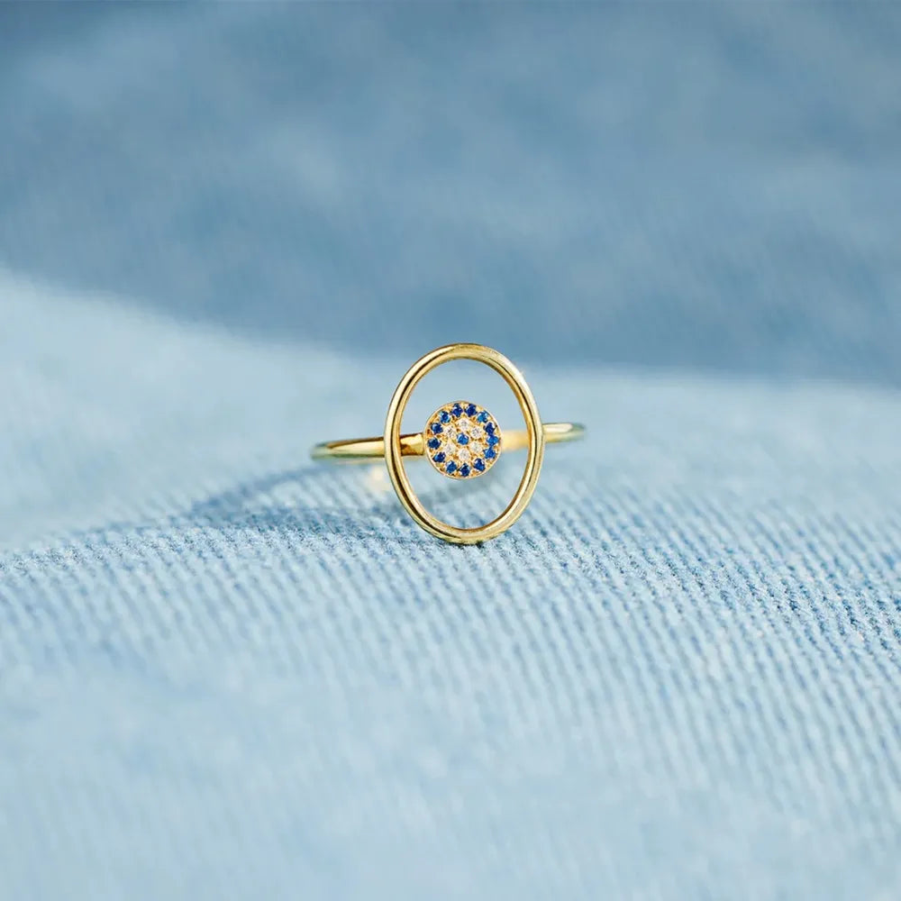 Gold oval ring with blue and clear evil eye detail
