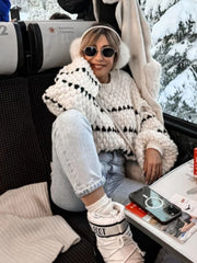 Textured stripe knit sweater with balloon sleeves in cream and black, styled casually.