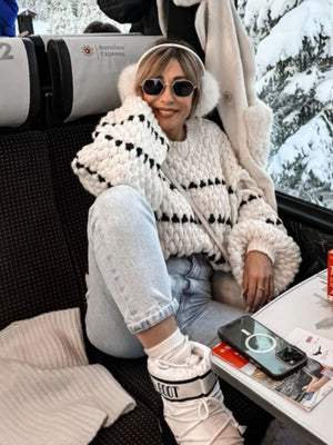 Textured stripe knit sweater with balloon sleeves in cream and black, styled casually.