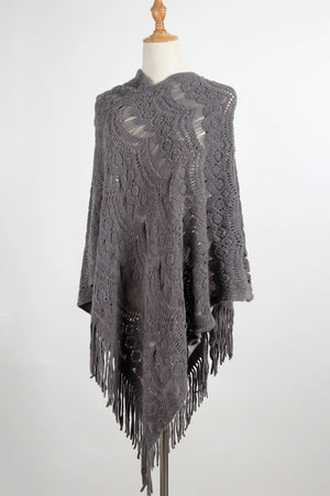 Dark gray crochet poncho with intricate openwork pattern and fringe detail.