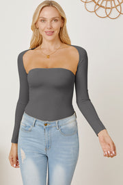 Dark gray long sleeve bodysuit with square neckline and open back detail, styled with jeans.