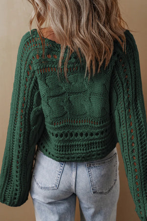Dark green acrylic cable knit sweater with cutout details and open knit patterns.